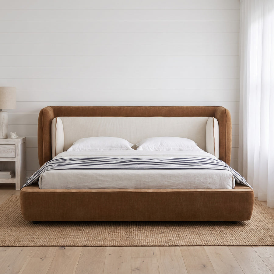 Cognac and off-white wingback bed in a coastal shiplap bedroom with jute rug, hazy diffuse daylight.