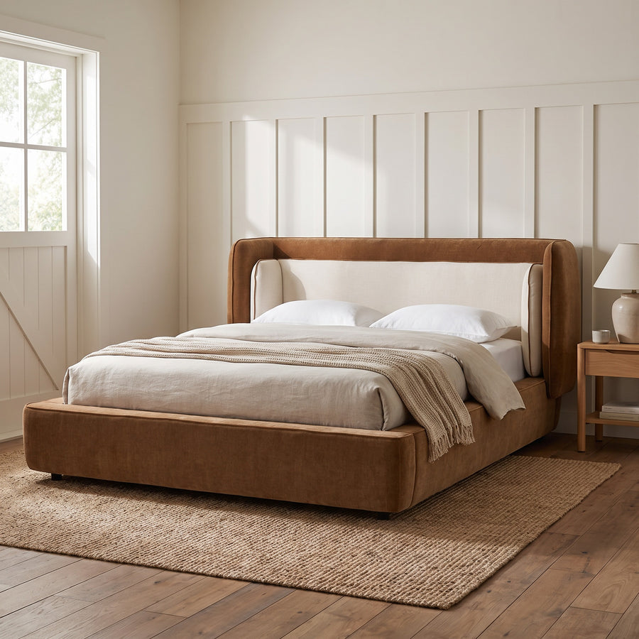 Cognac and off-white wingback bed in a farmhouse bedroom with board-and-batten wall and barn-style window, soft early-morning light.
