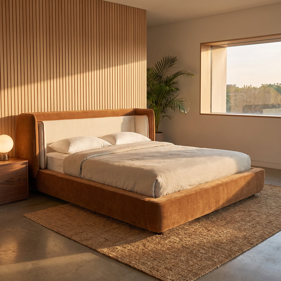 Cognac and off-white wingback bed in a mid-century bedroom with wood-slatted wall, warm golden-hour light.